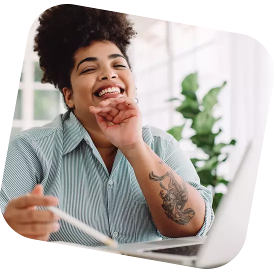 Femme sourire derrière ordinateur crédit assuré par FC Crédits & Finances