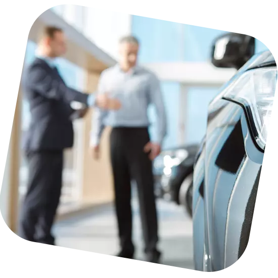 Homme en conversation avec un vendeur pour l'achat d'une nouvelle voiture